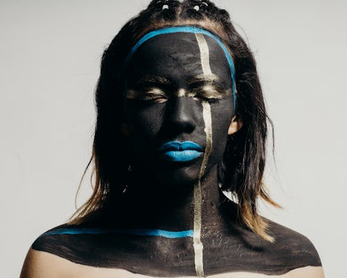 Woman with her Eyes Closed and Face Painted with Black and Blue Ink 