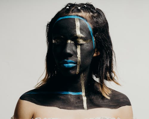 Woman with her Eyes Closed and Face Painted with Black and Blue Ink 