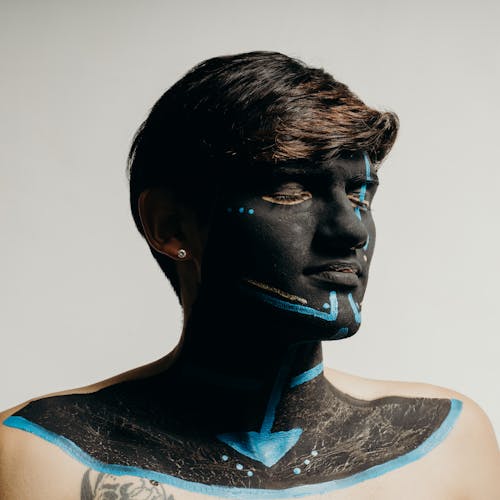 Man with his Eyes Closed and Face Painted with Black and Blue Ink 