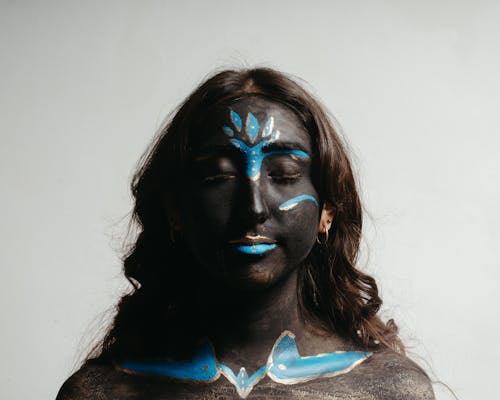 Woman with her Eyes Closed and Face Painted with Black and Blue Ink 