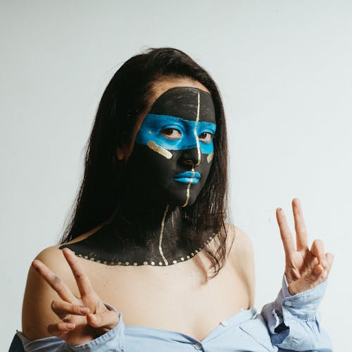 Woman with Face Paint doing Peace Sign 