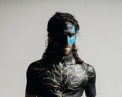 Portrait of Man with Face and Chest Painted Black and Blue