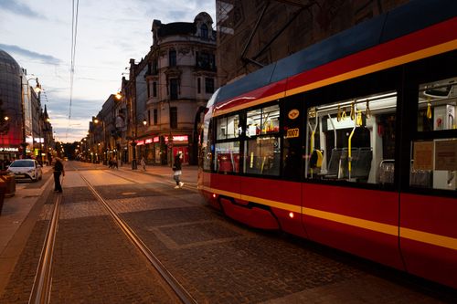 Free City street featuring a modern tramway during twilight with historic buildings. Stock Photo