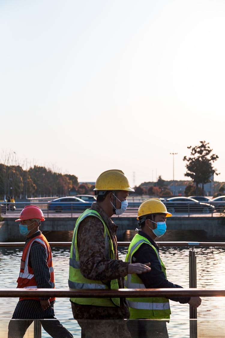 Photograph Of Men With Hard Hats Wearing Reflective Vests