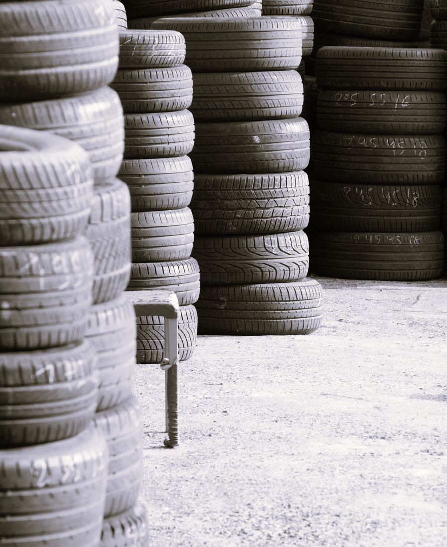 Tall stacks of black tires in a tire shop