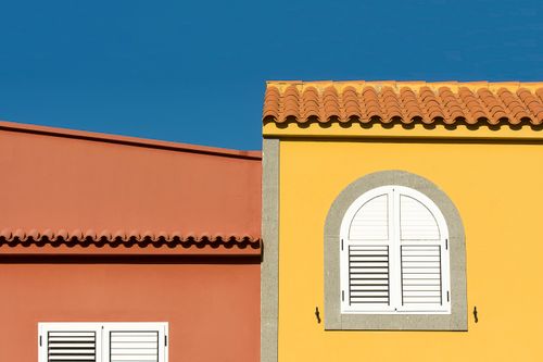Free Colorful Mediterranean building facade with arch windows under clear blue sky Stock Photo