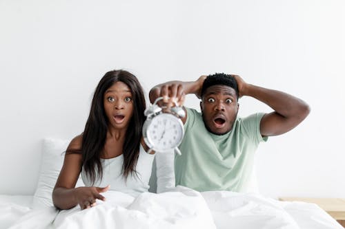 Couple in Bed with Alarm Clock