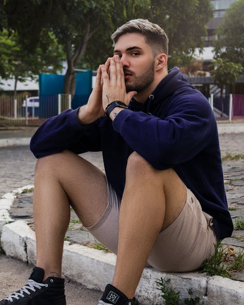 Free A Man in a Blue Hoodie Posing with His Hands Together Stock Photo