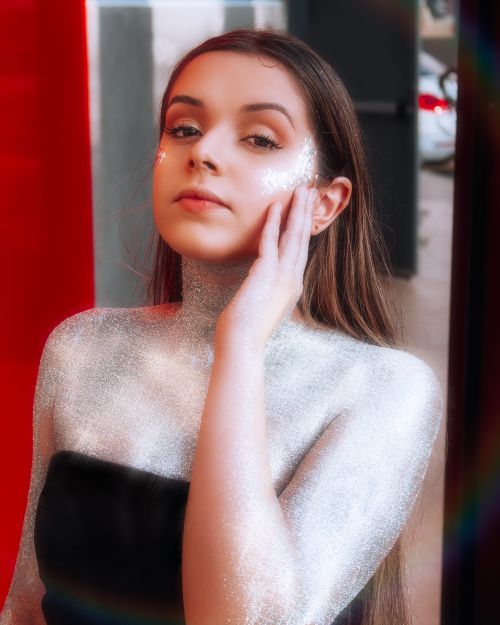 Free Elegant portrait of a young woman adorned in shimmering glitter, exuding a chic and glamorous vibe. Stock Photo