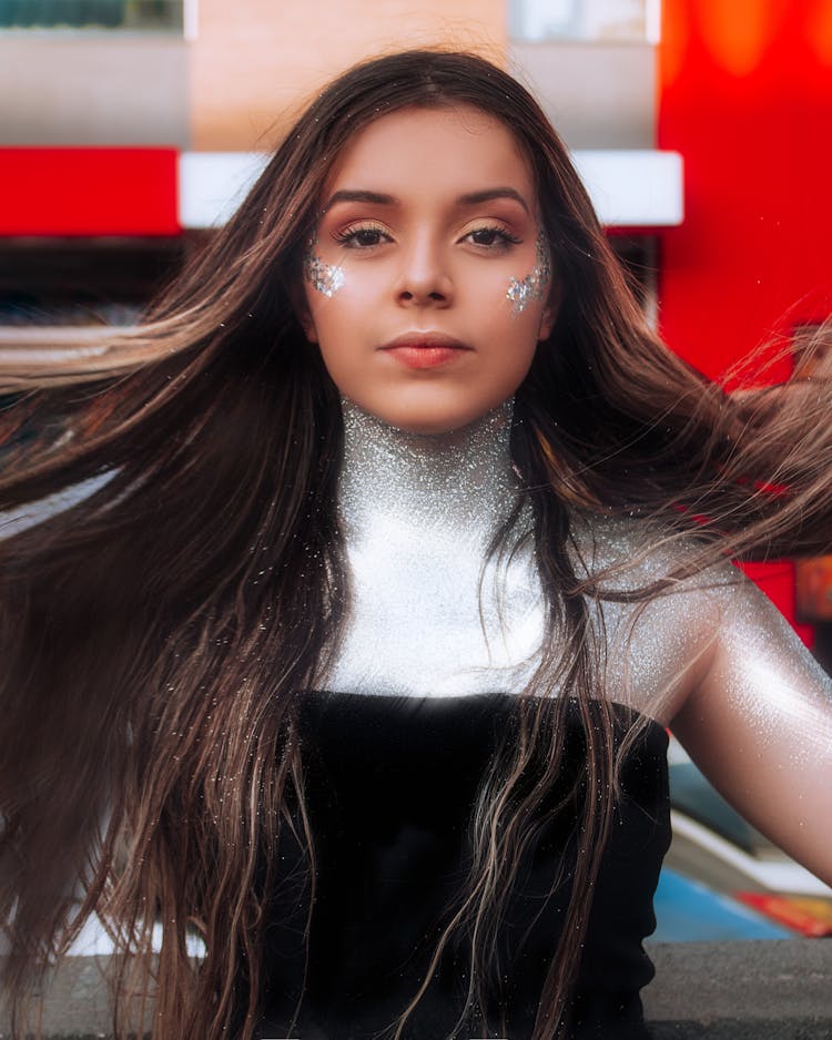 A Woman With Silver Glitters On Face And Body