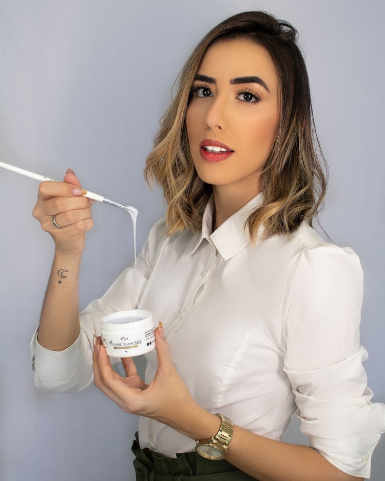 Woman Holding A Brush And A Jar With A Product