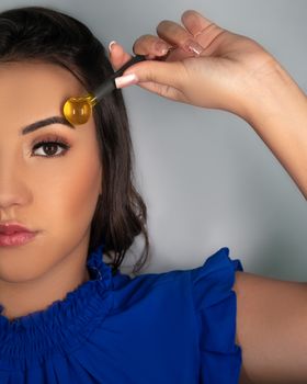 A woman using a roller for skincare enhancement, half face view.