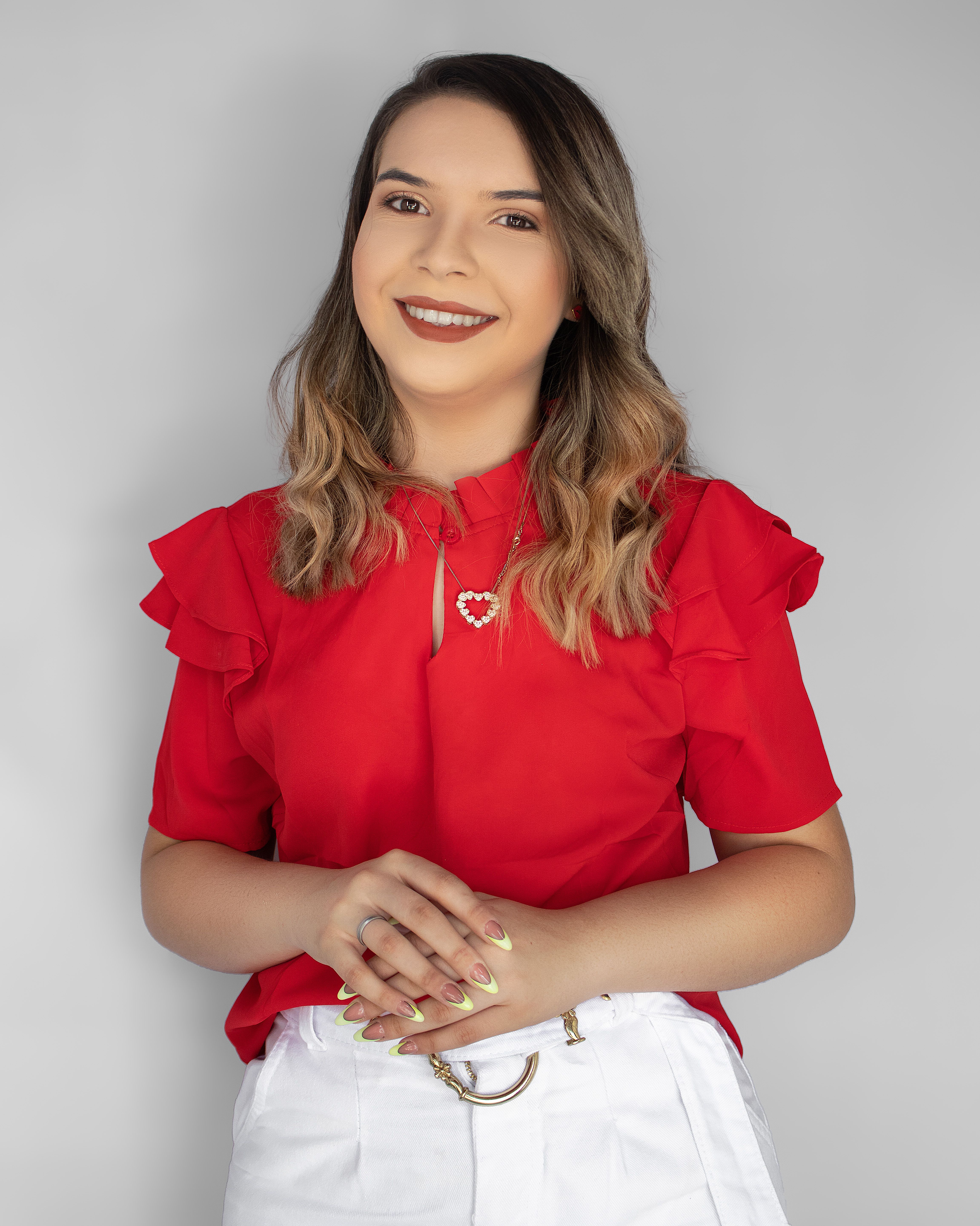 Portrait of a smiling woman in a red blouse against a neutral background.
