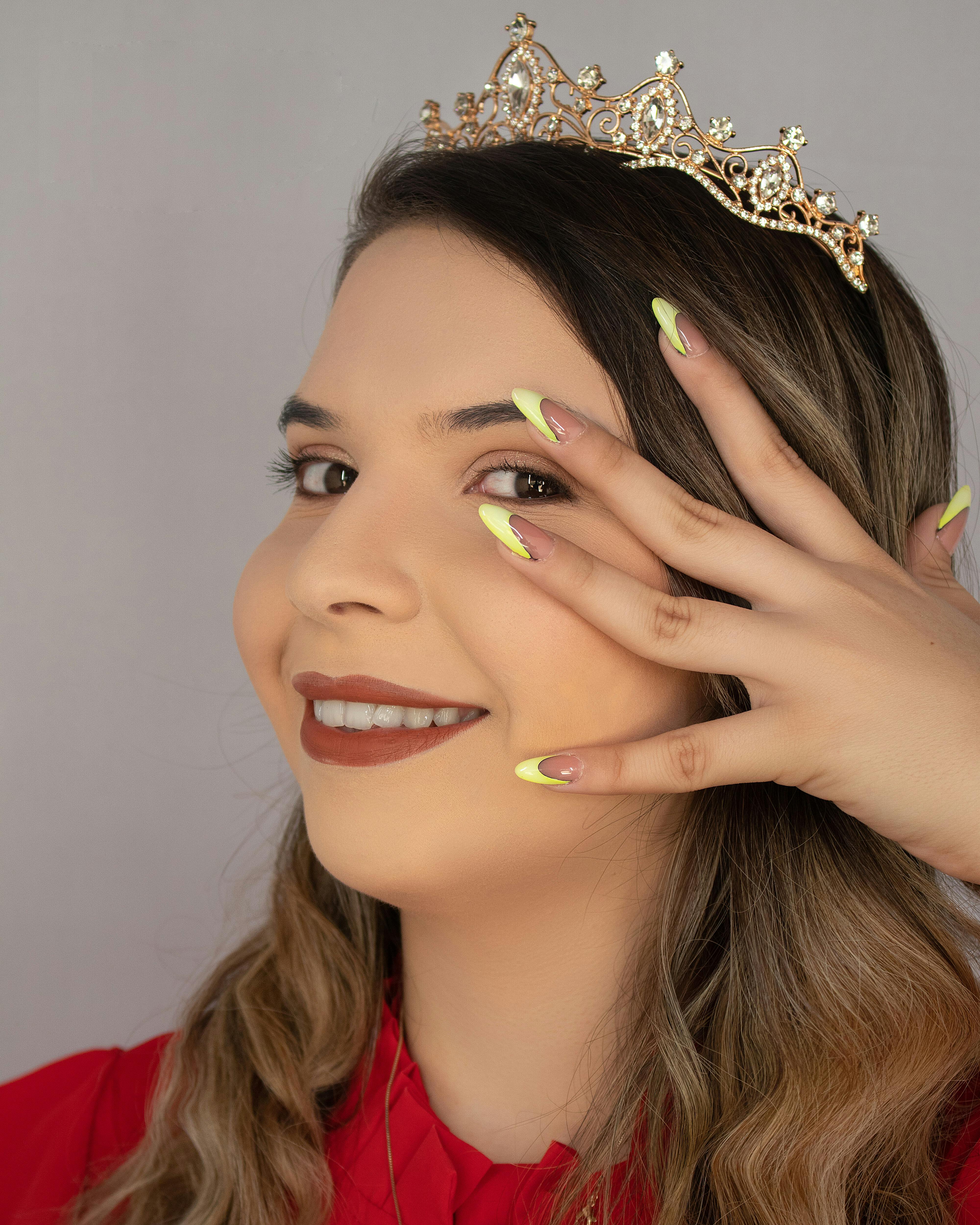 woman with manicured nails wearing a crown