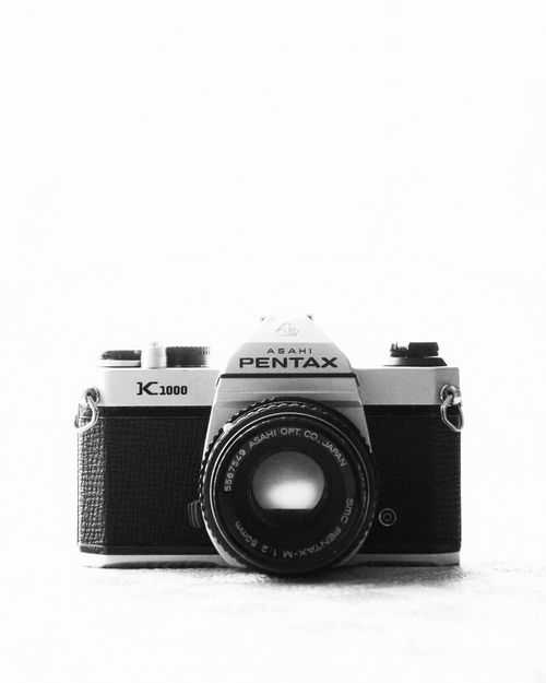 Free Classic black and white still life of a vintage Pentax K1000 camera showcasing retro design. Stock Photo