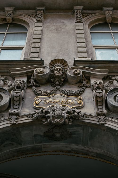 Free Detailed architectural facade with ornate bas relief and arched windows in a classic style. Stock Photo