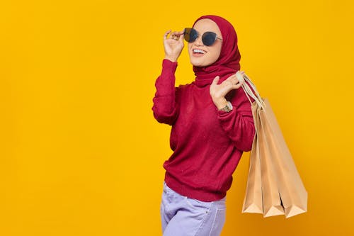 A Happy Woman in Red Hijab Holding Shopping Bags