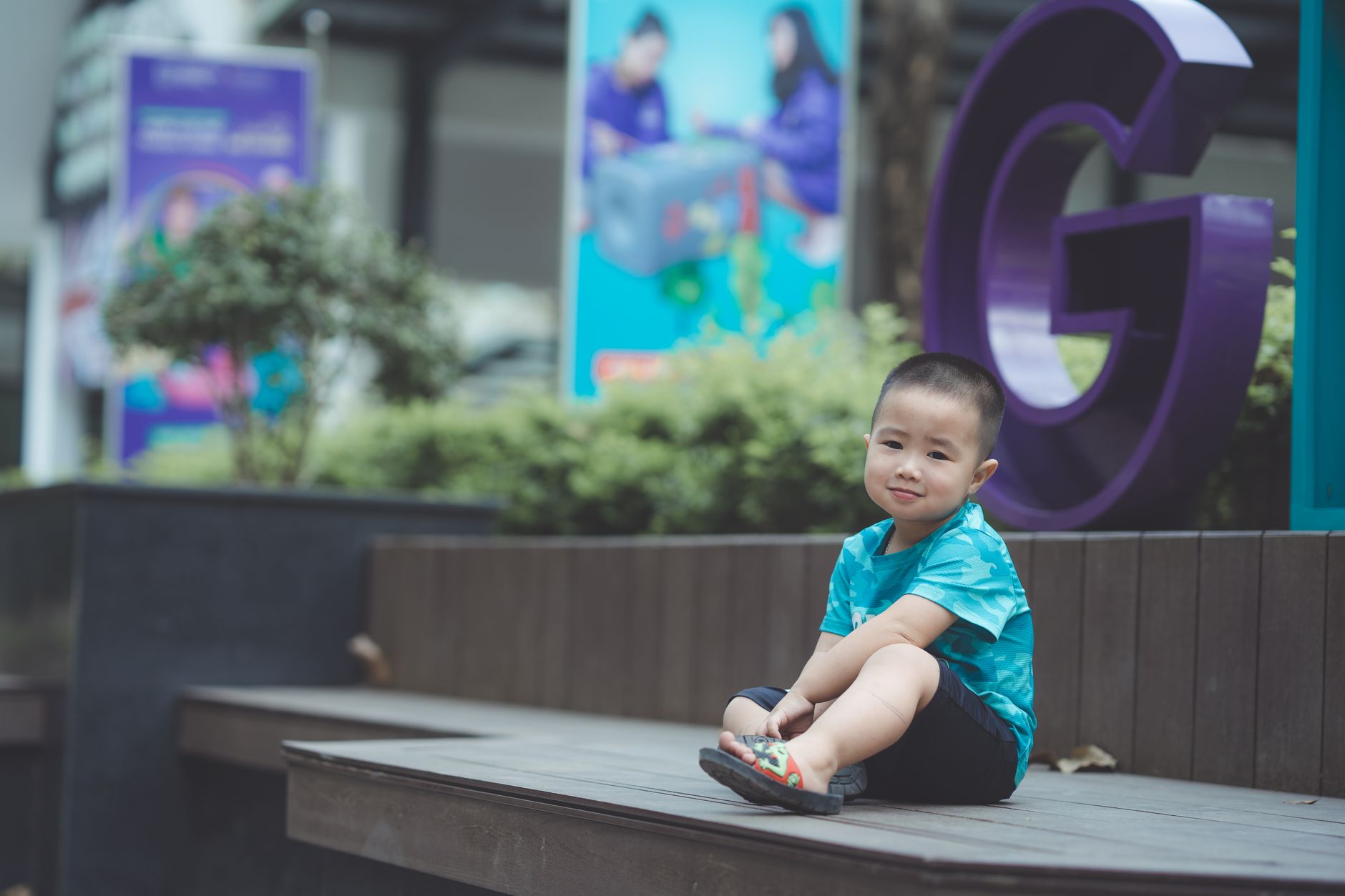 A cute child sitting on a wooden bench outdoors, exuding innocence and joy.