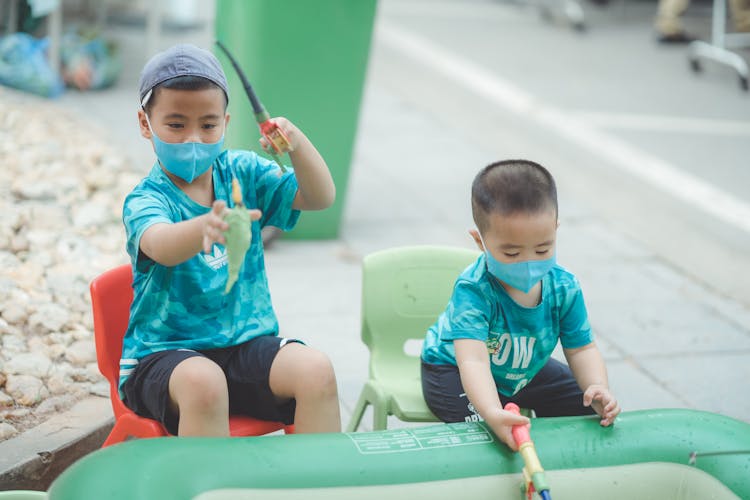 Happy Kids In Face Masks Playing With Fishing Rods