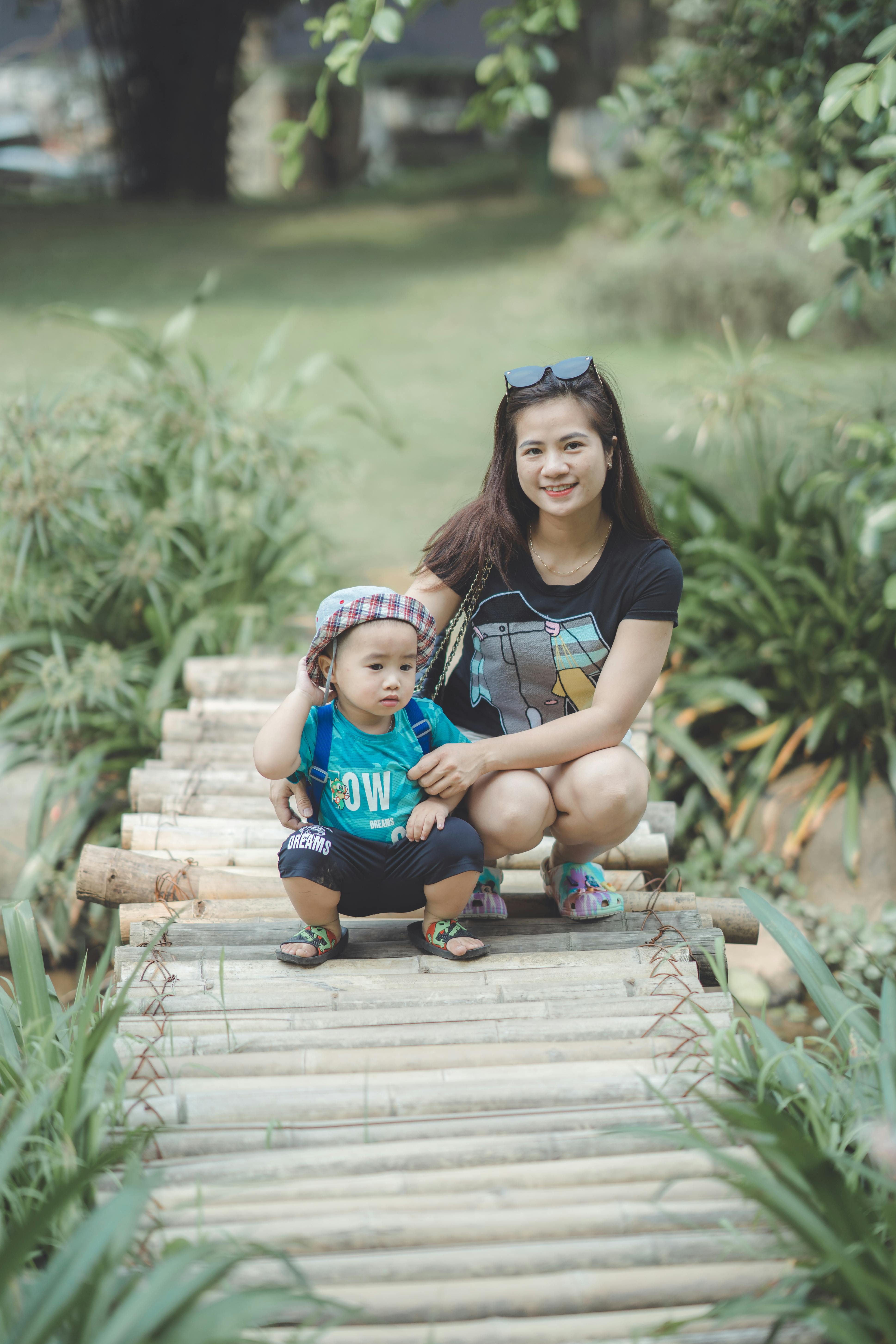 woman and a boy sitting on a bamboo boardwalk