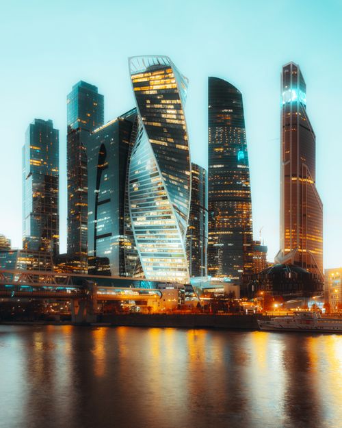 Free A breathtaking view of illuminated skyscrapers in Moscow's financial district at twilight, reflecting on the Moskva River. Stock Photo