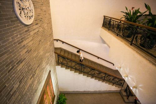 Free Person walking upstairs in an indoor setting with decorative elements and green plants. Stock Photo
