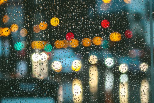 A cityscape through a rainy window, with colorful bokeh lights in New York.