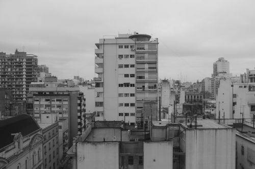 Free A black and white view of an urban cityscape with multiple buildings on a cloudy day. Stock Photo