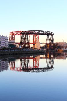 Reflection of Puente Transbordador bridge on a calm river in Buenos Aires.