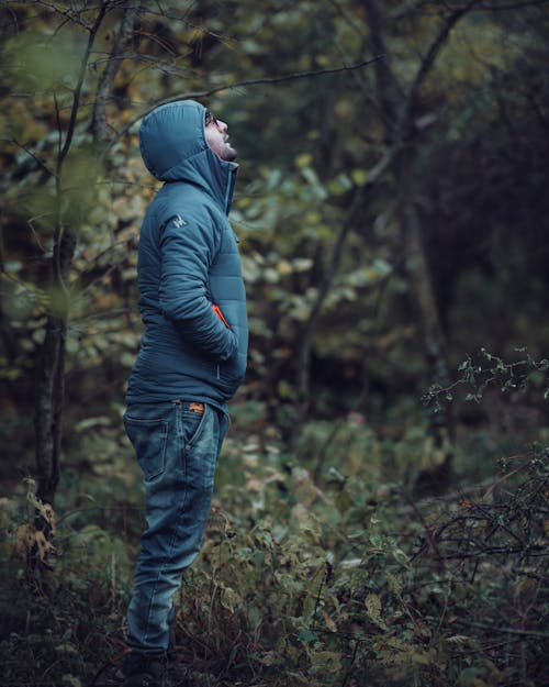 
A Man Wearing a Puffer Jacket in a Forest