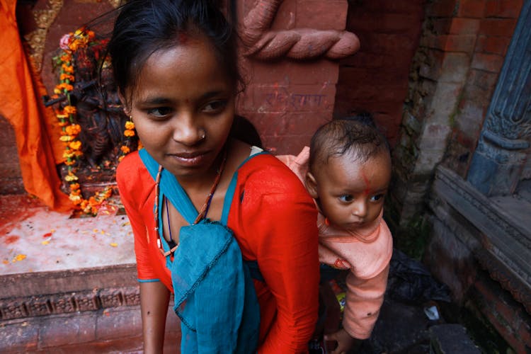 Woman Carrying A Baby From Behind