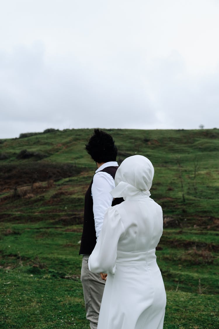 Couple Walking In Green Hilly Fields