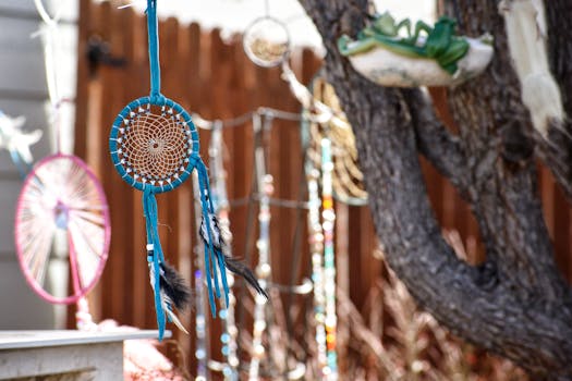 Vibrant dreamcatchers adorned with feathers hanging outdoors in the sunlight. Perfect for boho decor themes.