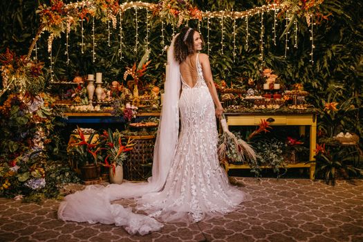 Bride in stunning wedding dress with floral decor in lush, tropical setting. Perfect for wedding themes.