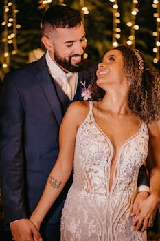 Bride and groom lovingly embrace at night under sparkling lights on their wedding day.