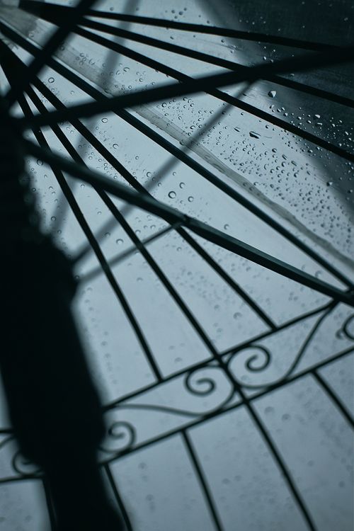 Free Intriguing vertical shot of raindrops on a decorative window, playing with light and shadow. Stock Photo