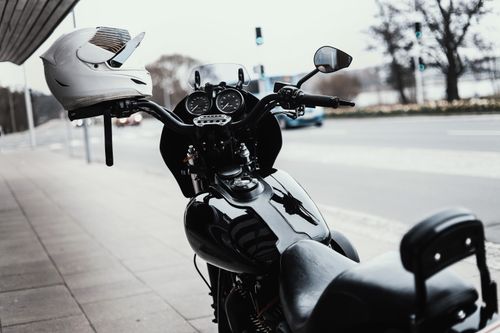 Free Close-up of a black motorcycle with helmet parked on a city street sidewalk in Silkeborg, Denmark. Stock Photo