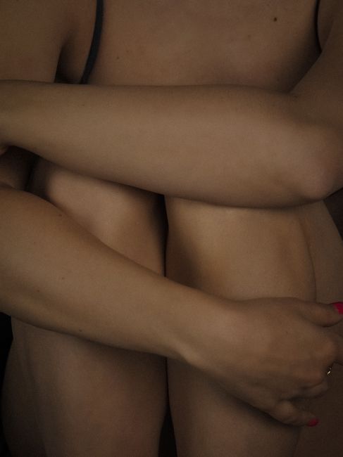 Fotomural Retrato artístico en primer plano de una mujer abrazándose a sí misma en un momento de intimidad.
