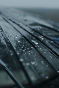 Detailed view of raindrops on a glass surface with a moody atmosphere.