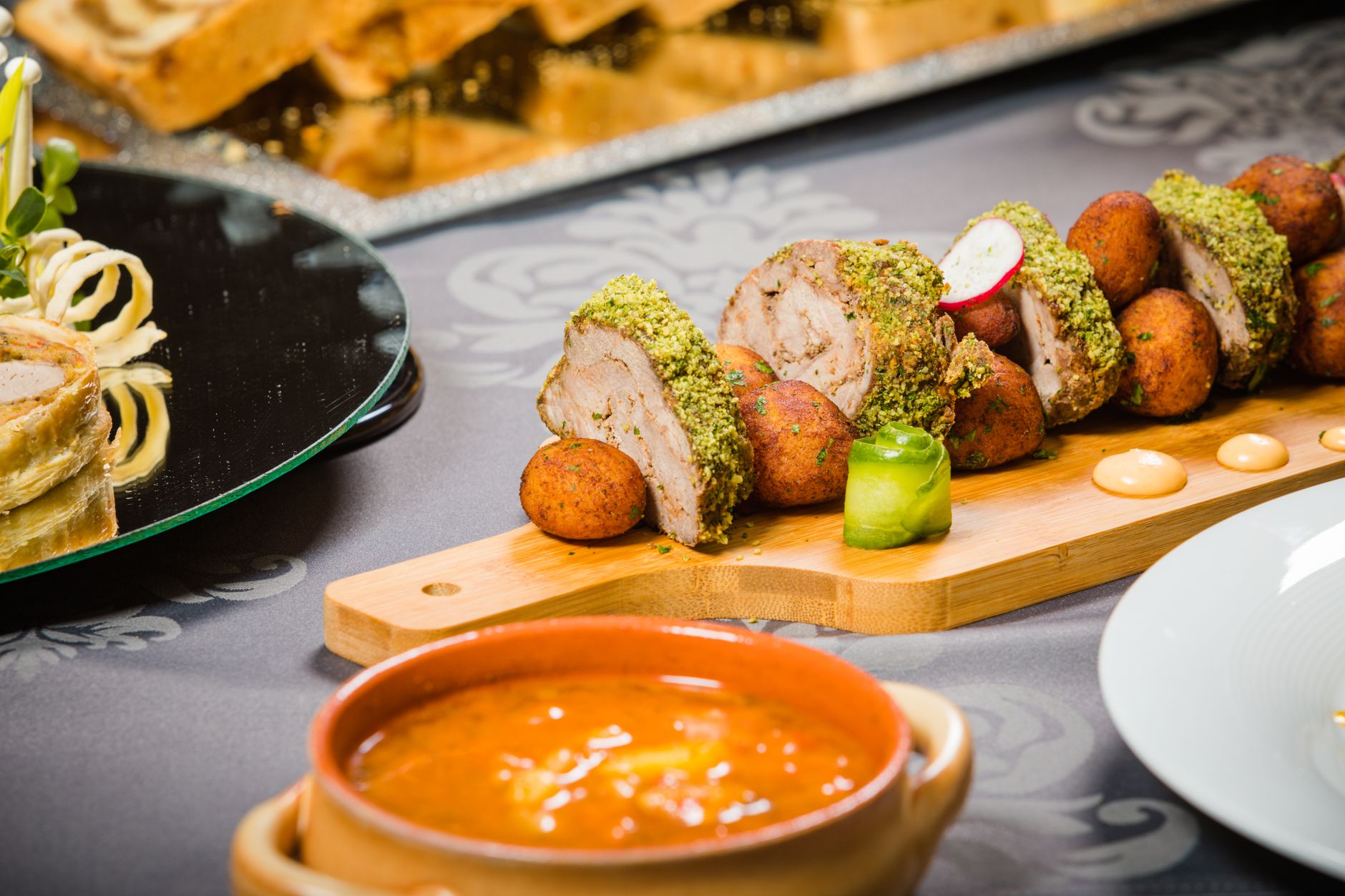 Close-up of a beautifully plated meat dish with various sides, perfect for a refined dining experience.