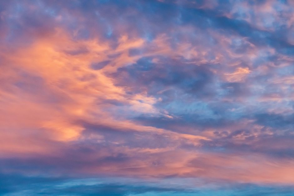 A mesmerizing display of pink and blue clouds during a vibrant sunset.