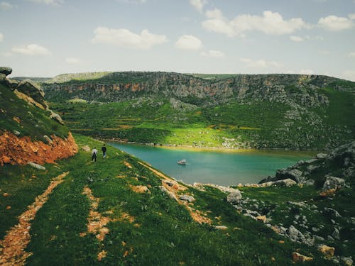 People Walking in Valley near Water 