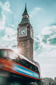 Dynamic shot of Big Ben with a red double-decker bus in motion, capturing urban London essence.