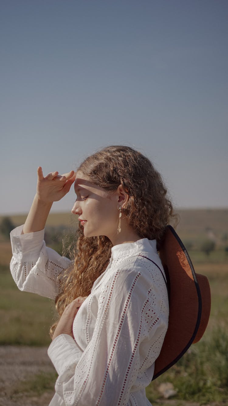 Woman Covering Eyes From Sunbeams