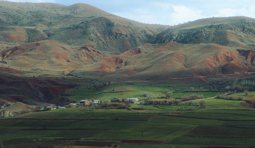Free Scenic view of rolling hills and vibrant farmland in a peaceful rural setting. Stock Photo