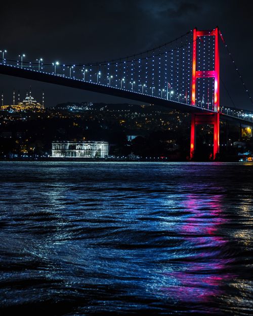 Free Stunning night view of the illuminated Bosphorus Bridge in Istanbul, Turkey, reflecting in the water. Stock Photo