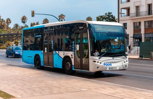 Free Public bus on a sunny day in Málaga, showcasing urban transportation. Stock Photo