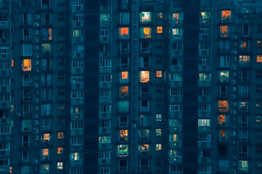 High-rise apartment building in Hangzhou, China, showcasing illuminated windows against a dark facade at night.