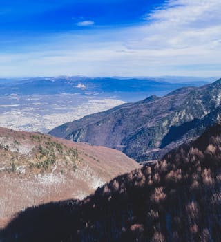 Stunning aerial view of a vast mountain range under a clear blue sky.