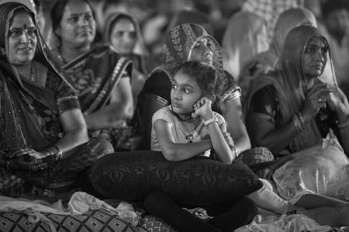 Grayscale Photo of a Girl Sitting on the Floor with Mature Women